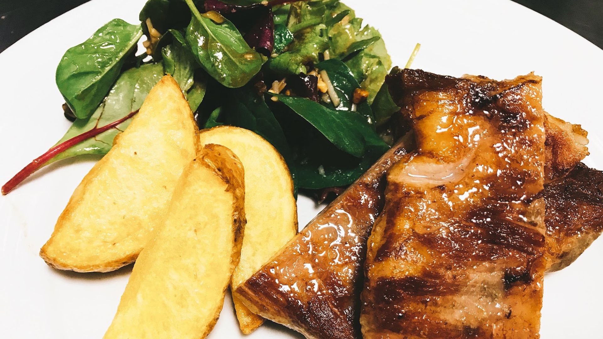 Costilla con guarnición de patatas y ensalada fresca, un plato tradicional del restaurante Alcrique en Pontevedra